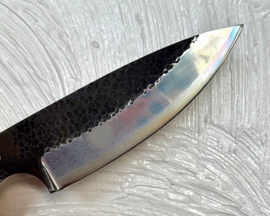 105mm collectible knife blade detail showing rough hammered black finish with mirror polish stainless steel damascus lines on bottom half of blade from SalterFineCutlery