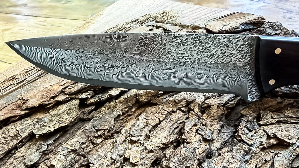 Detail photo of our special collectible fixed blade knife featuring a Japanese hand-forged blade with a combination of hammered 'claw' marks to honor our  beautiful and regal bald eagle on a river of damascus lines by SalterFineCutlery