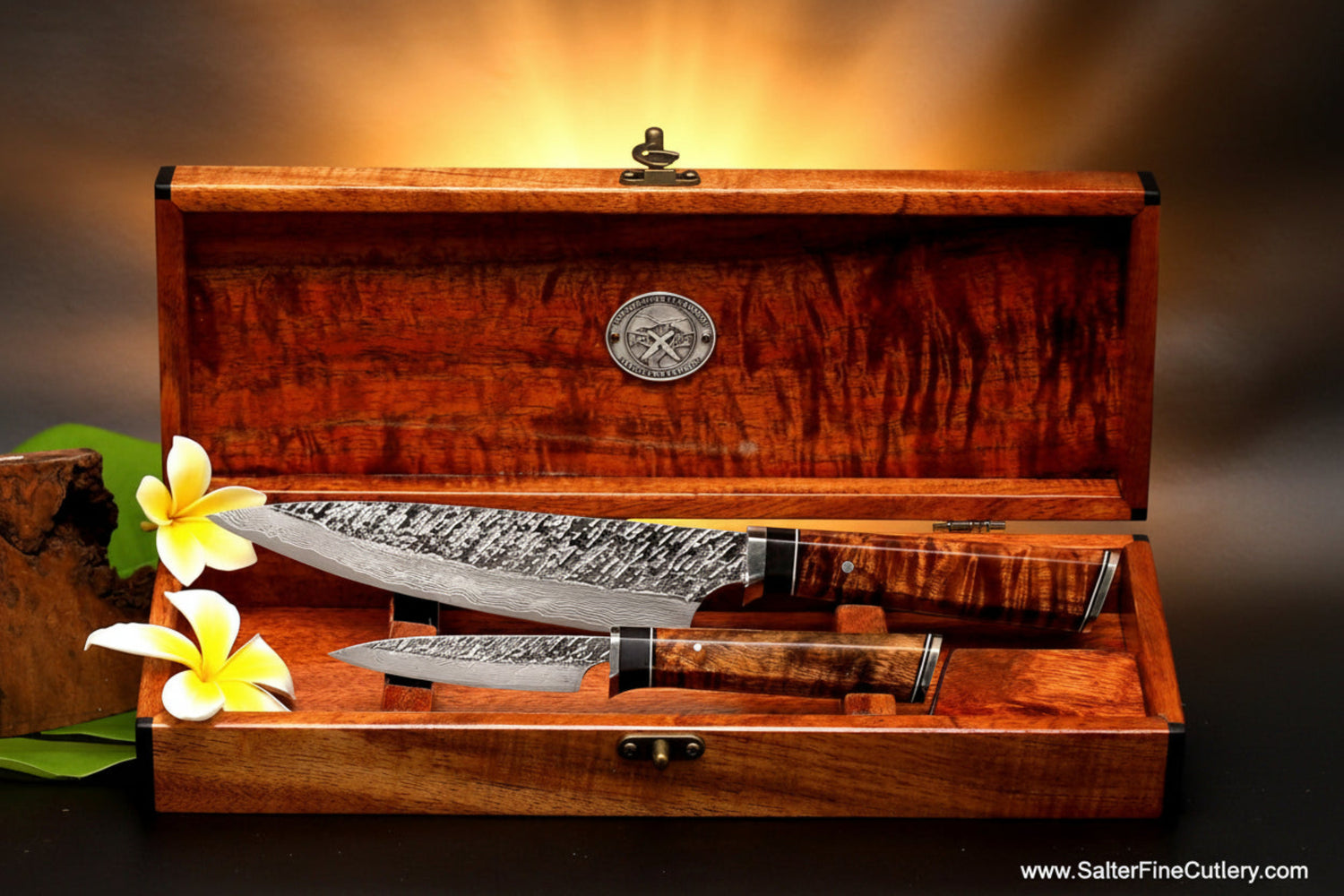 Two-piece handmade chef knife set from the VillageForge design series at SalterFineCutlery in Hawaii. Set is shown in open keepsake box also handcrafted from the same rare Hawaiian wood.