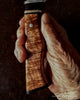 Detail view of decorative handle handmade by SalterFineCutlery featuring Hawaiian curly koa wood with accents of African blackwood  stainless steel brass 